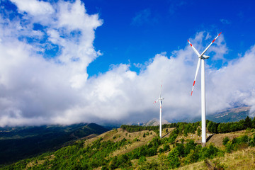 Wall Mural - Aerial view of wind turbine farm. Wind power plants in green summer landscape with clouds.