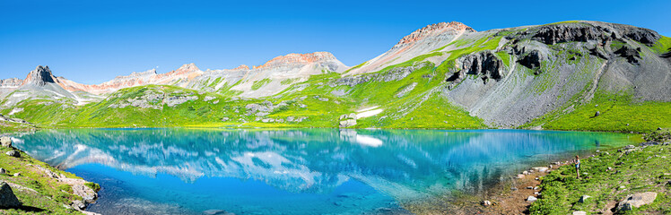 Panoramic view of turquoise vibrant Ice lake near Silverton, Colorado on summit rocky mountain peak and snow in August 2019 summer panorama