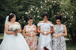 The bride with a wedding bouquet stands near her pregnant girlfriends. Girlfriends keep their hands on their bellies, forming a heart with their hands. Beautiful wedding bouquet