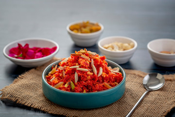 Wall Mural - Gajar ka halwa is a sweet dessert pudding from India made from carrot, served in a bowl. Garnished with cashew, almond and pistachio nuts.