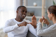 © fizkes - Smiling African American man and woman speaking sign language