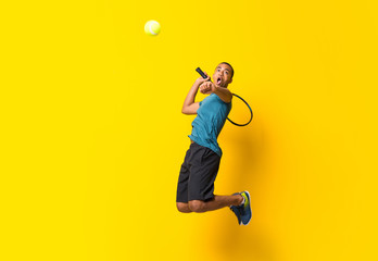 Wall Mural - Afro American tennis player man over isolated yellow background