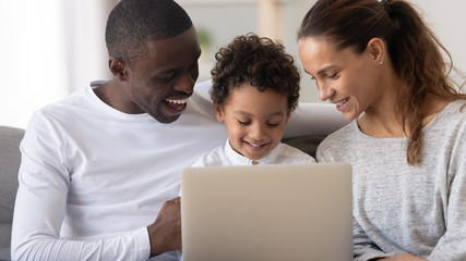 Wall Mural - Happy African American family with little son using laptop together