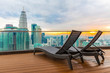 Sun loungers on the roof of a skyscraper overlooking Kuala Lumpur and sunset.
