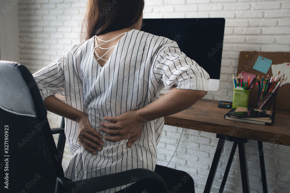 Business woman suffering from back pain in office - obrazy, fototapety, plakaty 