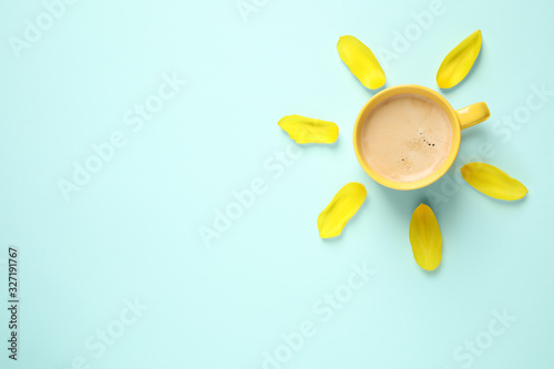 Cup of morning coffee and tulip petals on light blue background, flat lay Poster Mural XXL
