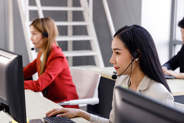 Asian call center operator type and concentrate to her work in personal computer. Concept for customer support service, lifestyle at office, employee.