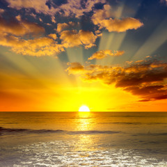 Poster - Majestic bright sunrise over ocean and orange clouds