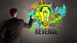 © ra2 studio - businessman drawing colorful light bulb with REVENUE inscription on textured concrete wall, new business idea concept