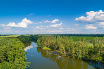 Wall Mural - Top view of a river in the countryside on a sunny day. Nature landscape with a beautiful cloudy sky. In summer