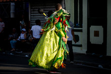 Young Man In Colorful Costume Pass By On City Street At Traditional Dominican Carnival