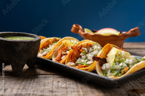 Fotomural Mexican pork tacos called Al pastor with pineapple on wooden background