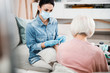 © Yakobchuk Olena - Female doctor sitting on couch with old woman