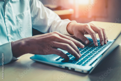 Fotomural Businessman hand typing on computer keyboard of a laptop computer in office
