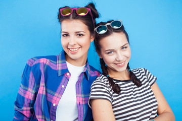 lifestyle people concept: two pretty young school teenage girls having fun happy smiling on blue background