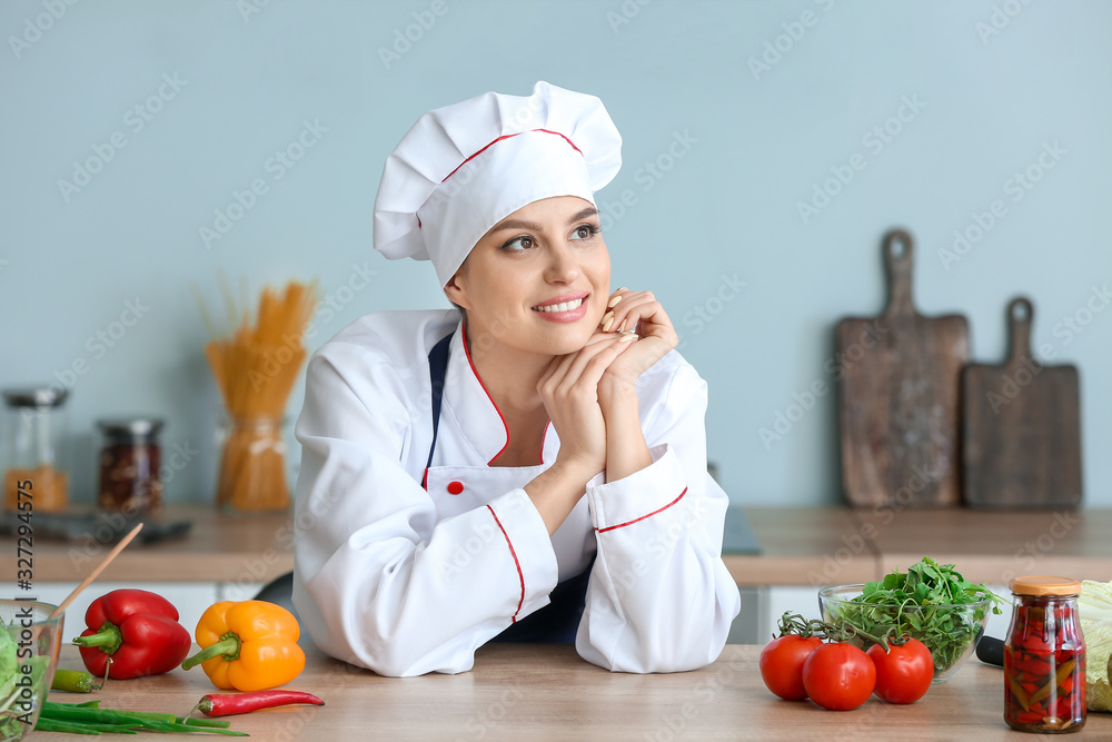 Beautiful female chef in kitchen