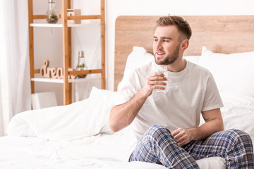 Canvas Print - Morning of young man drinking water in bedroom