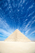 Blue sky view of the Great Pyramid with dramatic cloudscape on the Giza Plateau outside Cairo, Egypt