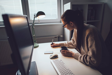 Wall Mural - Young woman working on computer at her home office