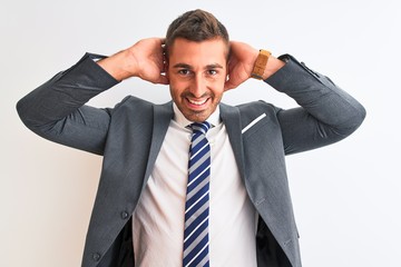 Wall Mural - Young handsome business man wearing suit and tie over isolated background relaxing and stretching, arms and hands behind head and neck smiling happy