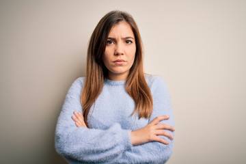 Canvas Print - Beautiful young woman wearing casual winter sweater standing over isolated background skeptic and nervous, disapproving expression on face with crossed arms. Negative person.