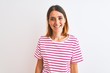 © Krakenimages.com - Beautiful redhead woman wearing casual striped pink t-shirt over isolated background with a happy and cool smile on face. Lucky person.