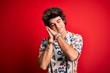 © Krakenimages.com - Young handsome man on vacation wearing summer shirt over isolated red background sleeping tired dreaming and posing with hands together while smiling with closed eyes.