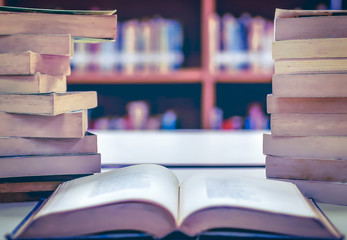 Poster - Stack of books in the library and blur bookshelf background	