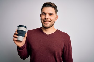 Wall Mural - Young man with blue eyes drinking coffee from take away plastic bottle over isolated background with a happy face standing and smiling with a confident smile showing teeth