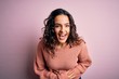 © Krakenimages.com - Young beautiful woman with curly hair wearing casual sweater over isolated pink background smiling and laughing hard out loud because funny crazy joke with hands on body.