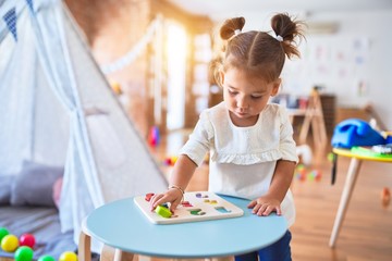 Young beautiful toddler learning mathematics playing with maths game at kindergaten