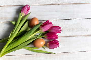 Canvas Print - Flat lay on red tulips and Easter eggs on white wooden background with copy space 