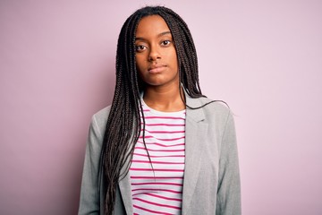 Poster - Young african american business woman standing over pink isolated background Relaxed with serious expression on face. Simple and natural looking at the camera.