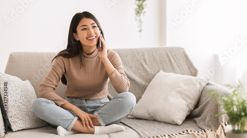 Fotomural Cheerful girl talking on phone with friend