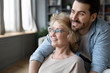 © fizkes - Hopeful mature mother and adult son visualizing at home
