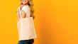 Eco-friendly lifestyle. Woman carrying white eco tote bag