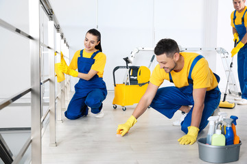 Canvas Print - Team of professional janitors cleaning room after renovation