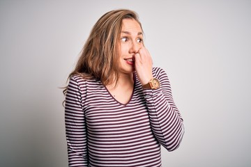 Canvas Print - Young beautiful blonde woman wearing casual striped t-shirt over isolated white background looking stressed and nervous with hands on mouth biting nails. Anxiety problem.