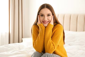 Canvas Print - Young woman wearing warm sweater on bed at home. Winter season