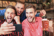 © ty - Diverse football fans watching football on smartphone and celebrating victory score in pub.