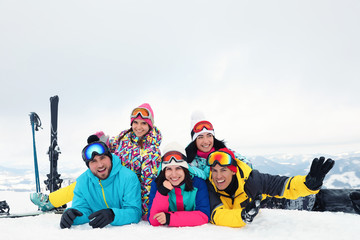 Group of friends with equipment in snowy mountains. Winter vacation