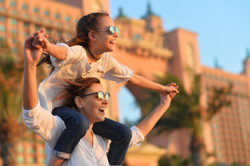 Portrait of happy mother giving daughter piggyback ride