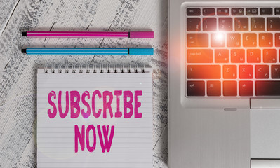 Poster - Writing note showing Subscribe Now. Business concept for to pay money to an organization in order to receive a service Metallic laptop blank ruled notepad pens lying old wooden vintage table