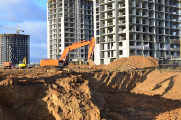 Wall Mural - Excavator load the sand to the heavy dump truck on construction site. Excavators and dozers digs the ground for the foundation and construction of a new building. Apartment renovation program