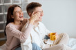 © the faces - cheerful laughing girl preparing a present for her boyfriend, man holding a cup of tea, drinking coffee. close up side view photo. relationship, positive mood