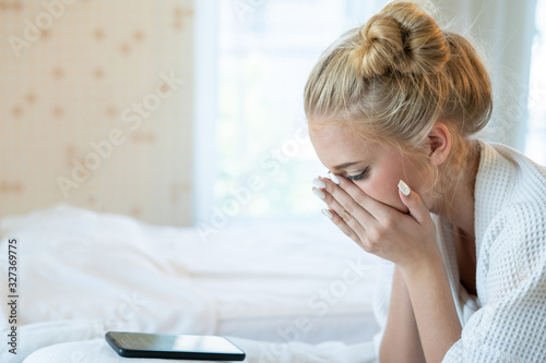 Caucasian woman in pajamas sleep alone in bed with loneliness. Typing message in smartphone for contact her husband come back home. Crying, sad because of quarrel and not understanding each other