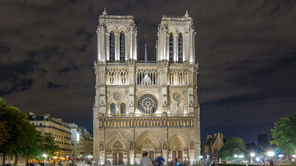 Wall Mural - Night View of Notre Dame de Paris timelapse, France and square in front of the cathedral with people