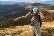 © Sokirlov - Woman the top of the mounting and looking at a beautiful landscape. Woman with backpack achieving the top the enjoying sunlit.
