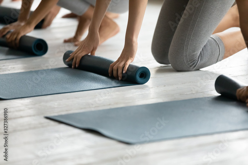 Fotomural Group of women fold up mats after yoga work out close up