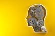 Gears cogwheels in human head shape over yellow background - strategy, creative or business innovation modern minimal concept